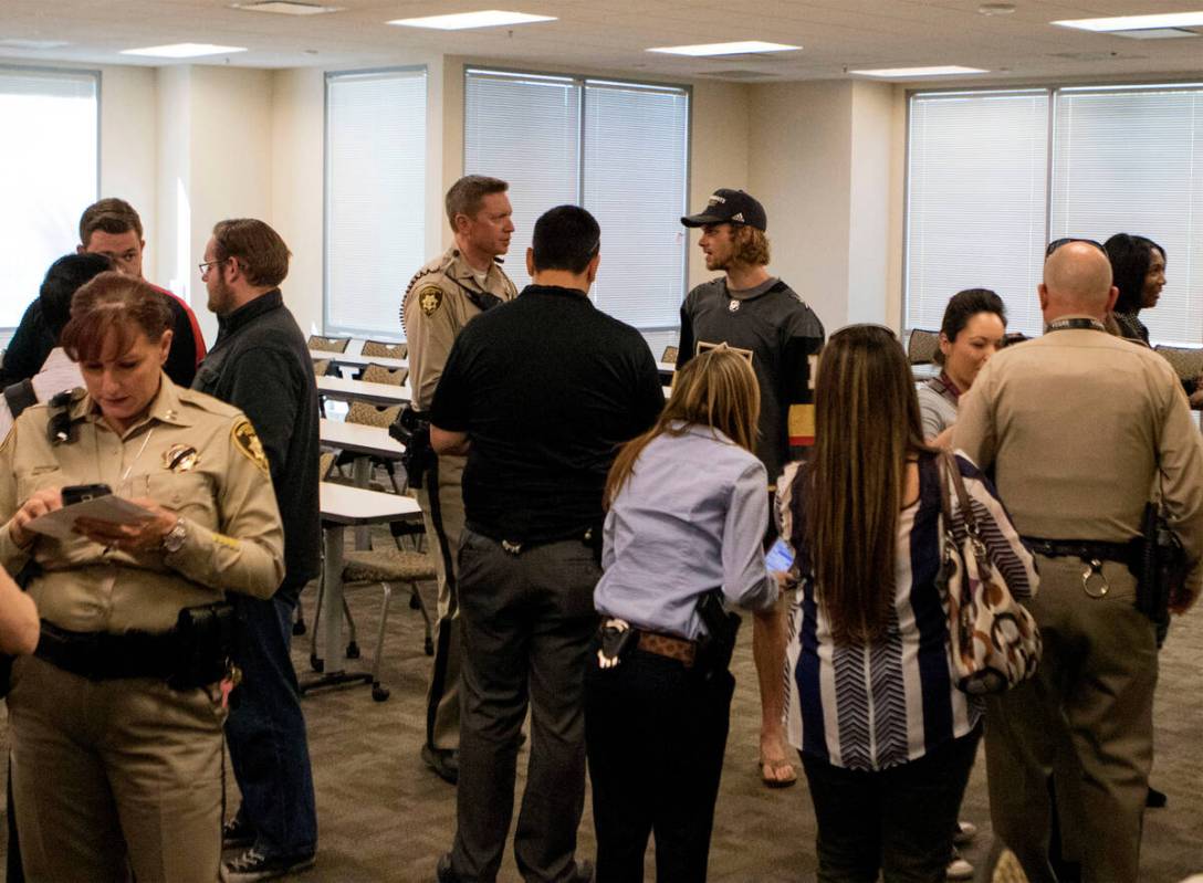 Metro officers and personnel gather around Vegas Golden Knights defenseman Jon Merrill (15) dur ...