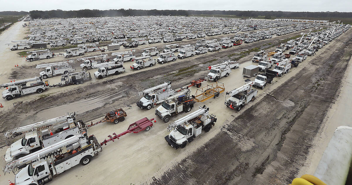 Utility trucks are staged in a rural lot in The Villages of Sumter County, Fla., Wednesday, Sep ...