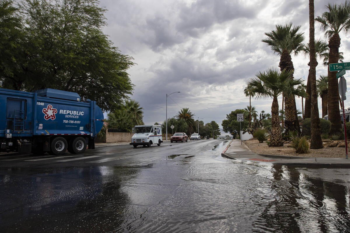 Vehicles travel along Oakey Boulevard as water pools in the road at 15th Street following rain ...