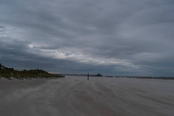 Bands of clouds sweep by a deserted beach as the effects from Hurricane Ian are felt, Thursday, ...