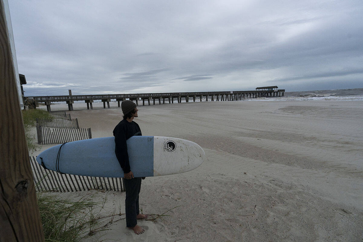 Alex Tatlock, from Savannah, Ga., checks out the surf, and decides against surfing, as the effe ...
