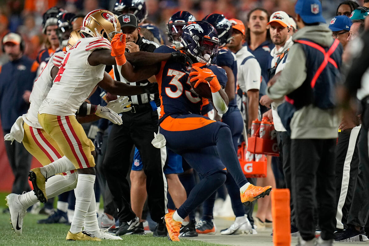 Denver Broncos running back Javonte Williams, right, is pushed out of bounds by San Francisco 4 ...