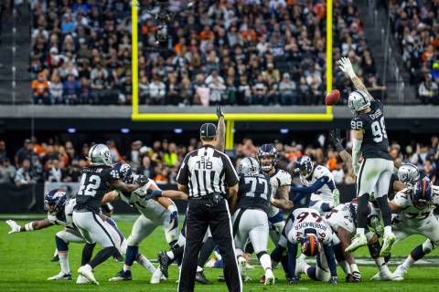 Raiders defensive end Maxx Crosby (98) elevates for a blocked field goal attempt on the Denver ...