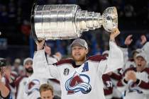 Colorado Avalanche center Nathan MacKinnon lifts the Stanley Cup after the team defeated the Ta ...