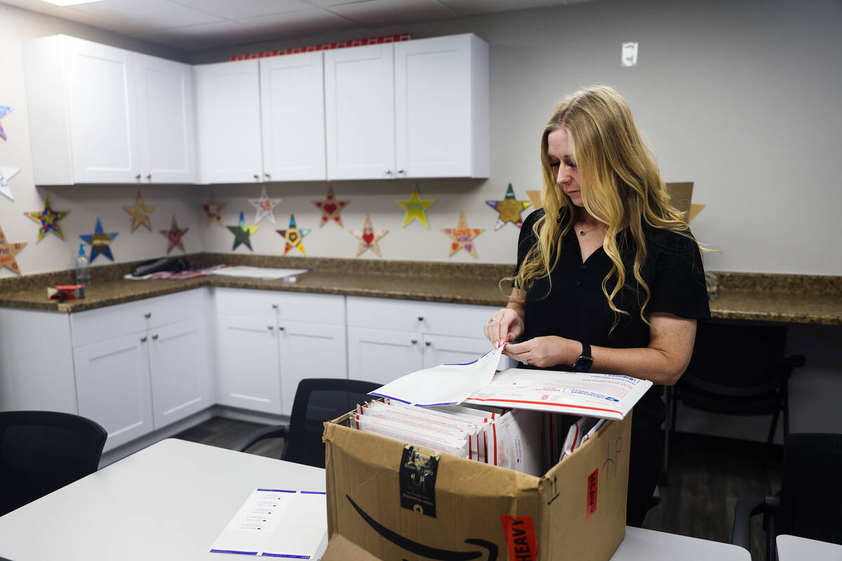 Tennille Pereira, director of the Vegas Strong Resiliency Center, stamps addresses to envelopes ...