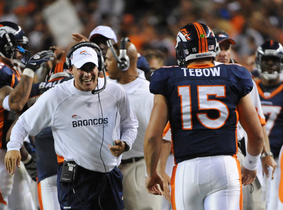 Denver Broncos head coach Josh McDaniels congratulates Tim Tebow (15) after Tebow threw a touch ...