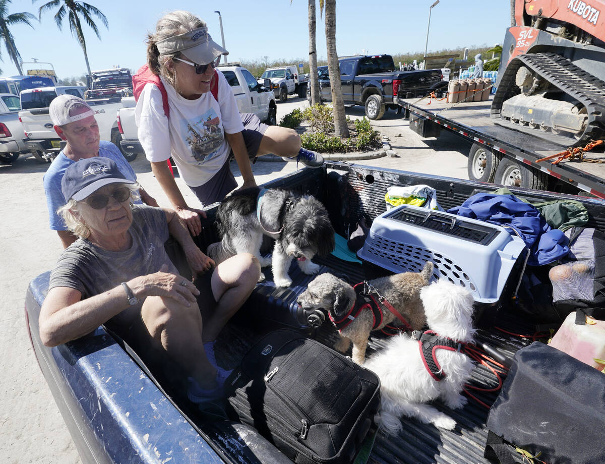 Steve Gibson, left background, helps Maria Zoltac into the back of his truck as her sister Susa ...