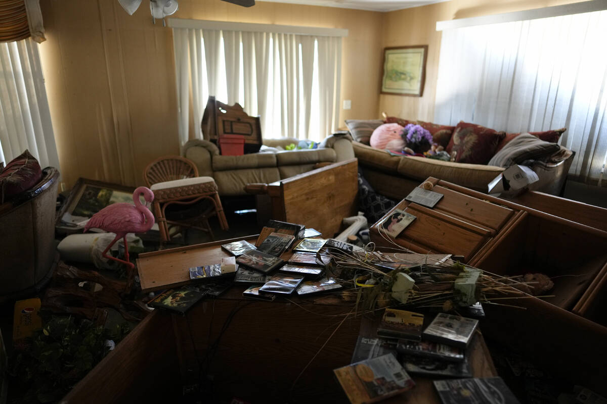 Furniture and personal items lie jumbled in the living room of Nita Ross, 79, as she returns to ...