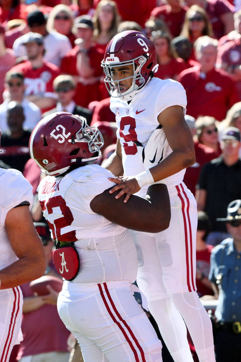 Alabama quarterback Bryce Young (9) celebrates with offensive lineman Tyler Booker (52) after s ...