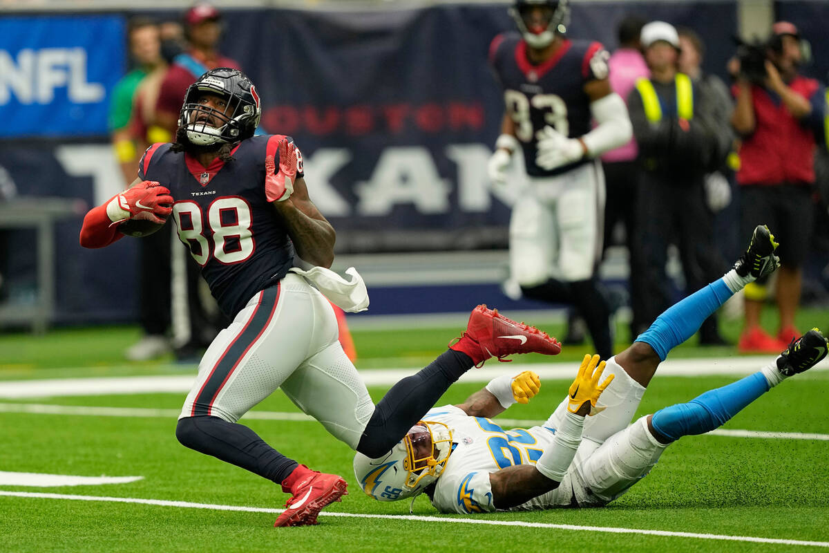Houston Texans wide receiver John Metchie III (88) is tripped up by Los Angeles Chargers corner ...