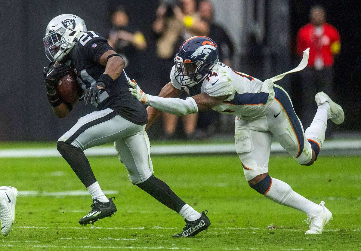Raiders cornerback Amik Robertson (21) evades a tackle by Denver Broncos wide receiver Courtlan ...