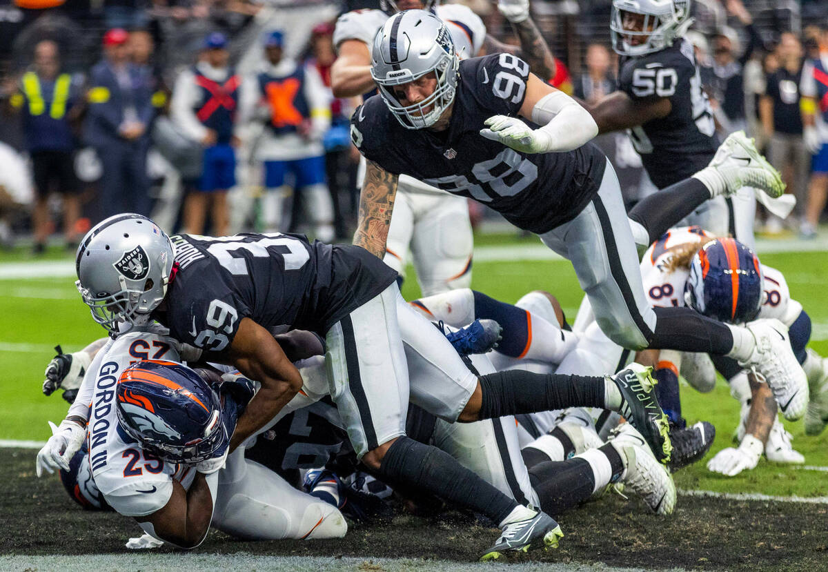 Denver Broncos running back Melvin Gordon III (25) is driven back into the end zone by Raiders ...