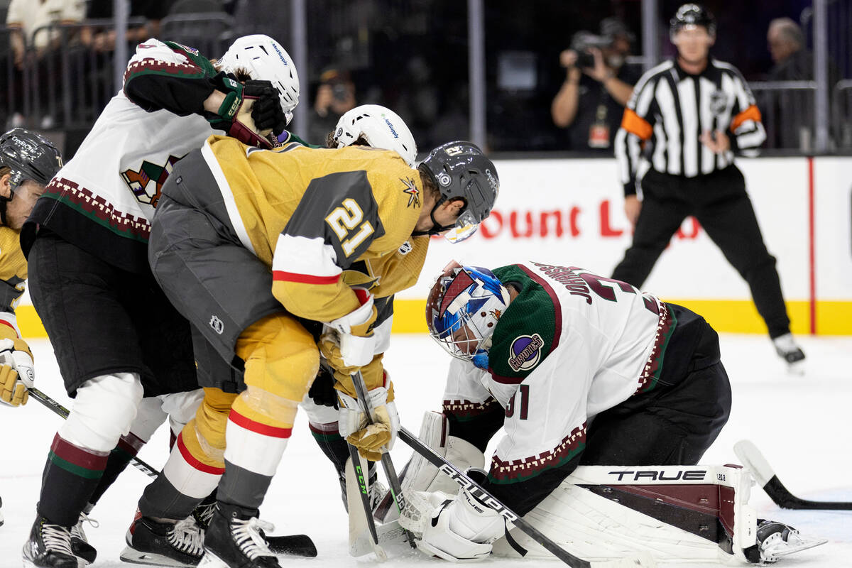 Golden Knights center Brett Howden (21) fights for a goal against Coyotes goaltender Jonas Joha ...