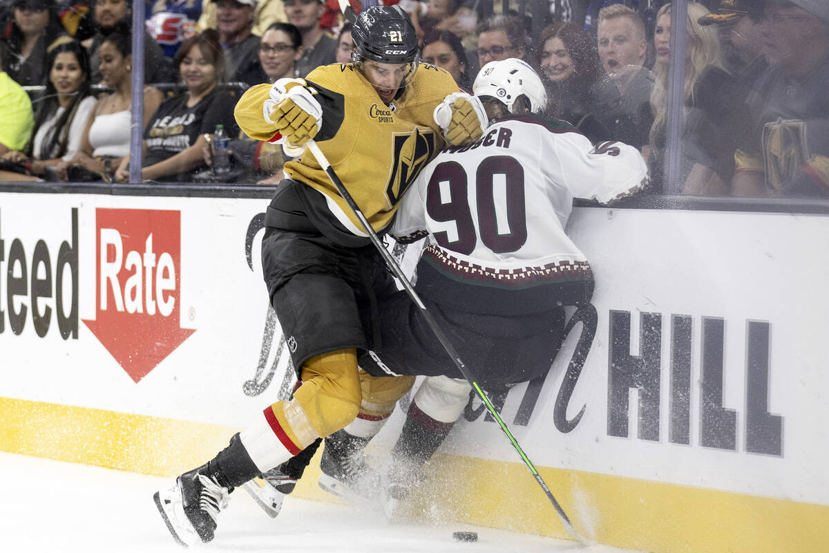 Golden Knights center Brett Howden (21) slams Coyotes defenseman J.J. Moser (90) into the board ...