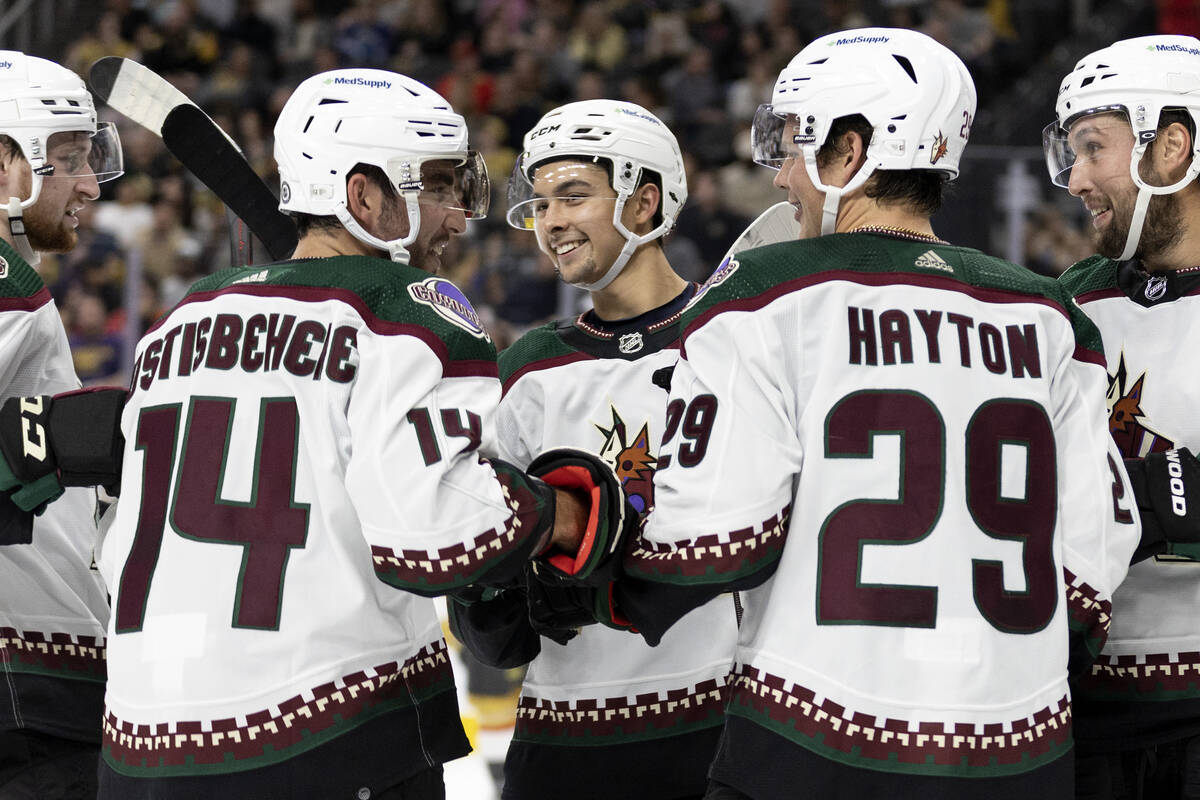 Coyotes players including defenseman Shayne Gostisbehere (14), Coyotes forward Dylan Guenther, ...