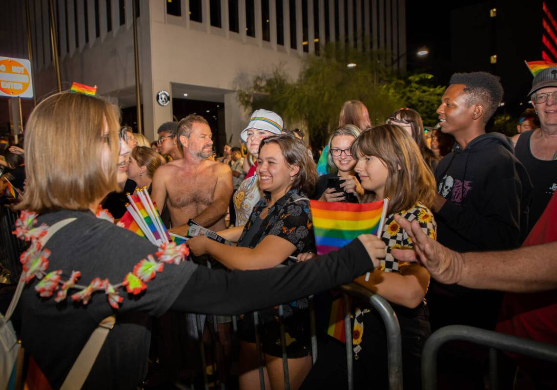 Participants in the annual Pride parade hand out rainbow flags to the crowd on Friday, Oct. 7, ...