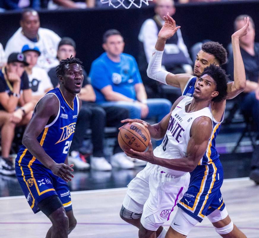 NBA G League Ignite guard Scoot Henderson (0) gets inside of Metropolitans 92 center Victor Wem ...