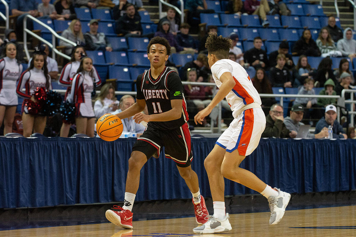 Liberty's Christopher Nwuli Dedan Thomas Jr. brings the ball up the court guarded by John Moble ...