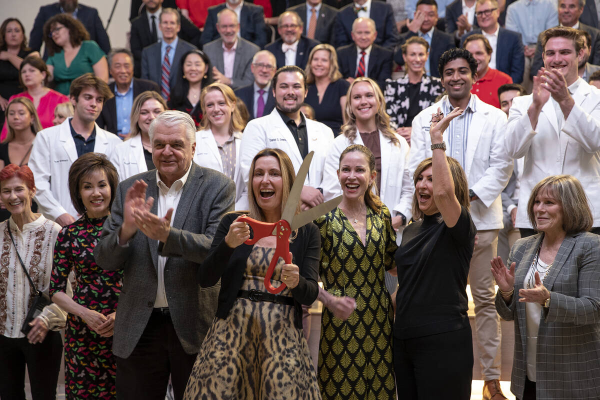 Lindy Schumacher, Nevada Health and Bioscience Corp. board member, cuts a ribbon surrounded by ...