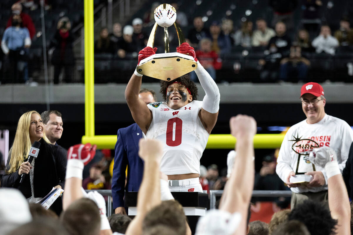 Wisconsin Badgers running back Braelon Allen (0) holds up the game-winning trophy while his tea ...
