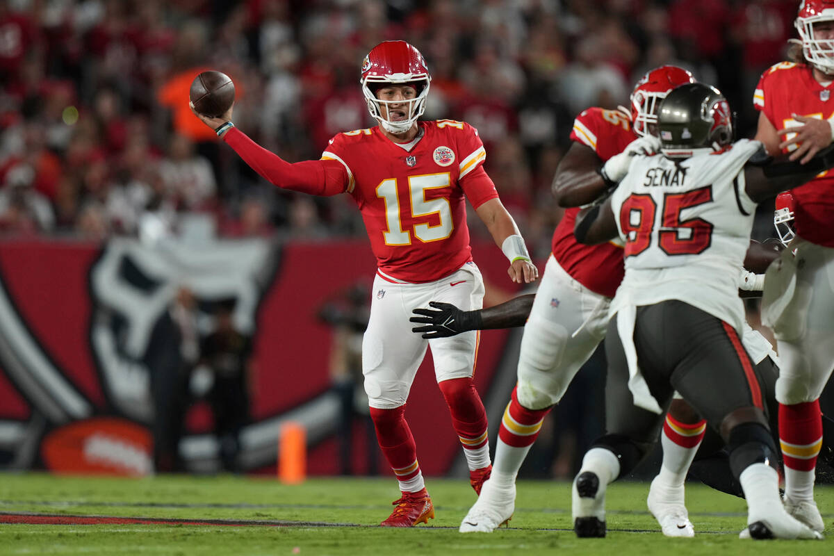 Kansas City Chiefs quarterback Patrick Mahomes (15) makes a pass attempt as he fights off a tac ...