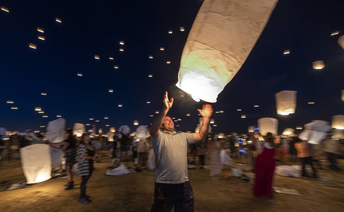 A participant releases his lantern with the group during the RiSE Lantern Fest at the Jean Dry ...