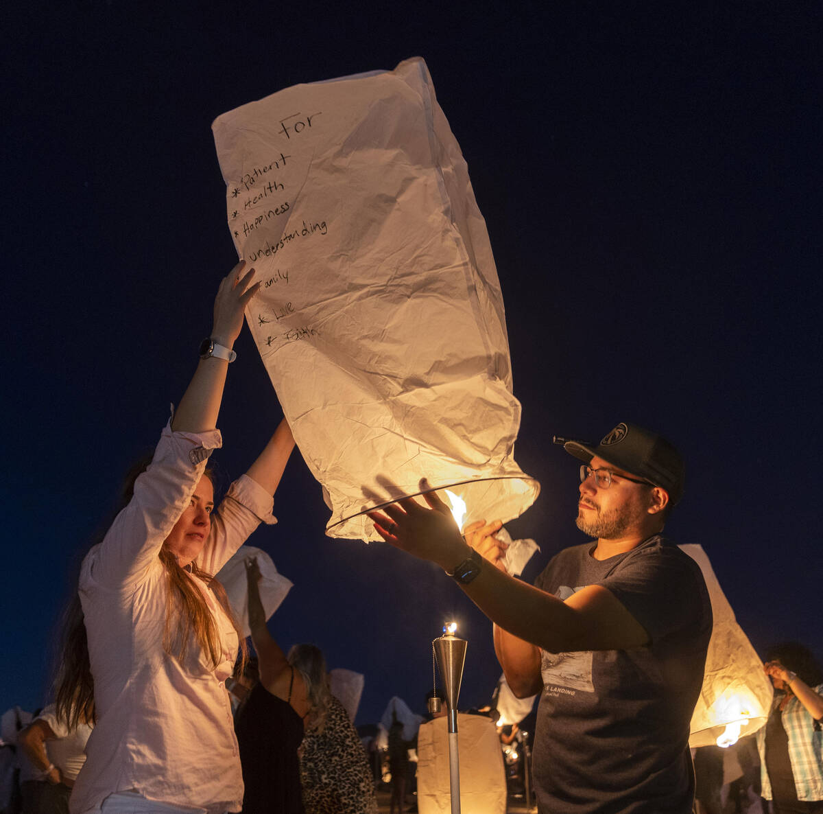 (From left) Maribeli and Joel Ramirez of San Diego prepare to release a lantern during the RiSE ...