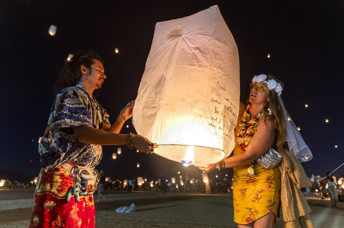 (From left) Aurora Benito and Sarah McGaffey of California release a lantern as part of the gr ...