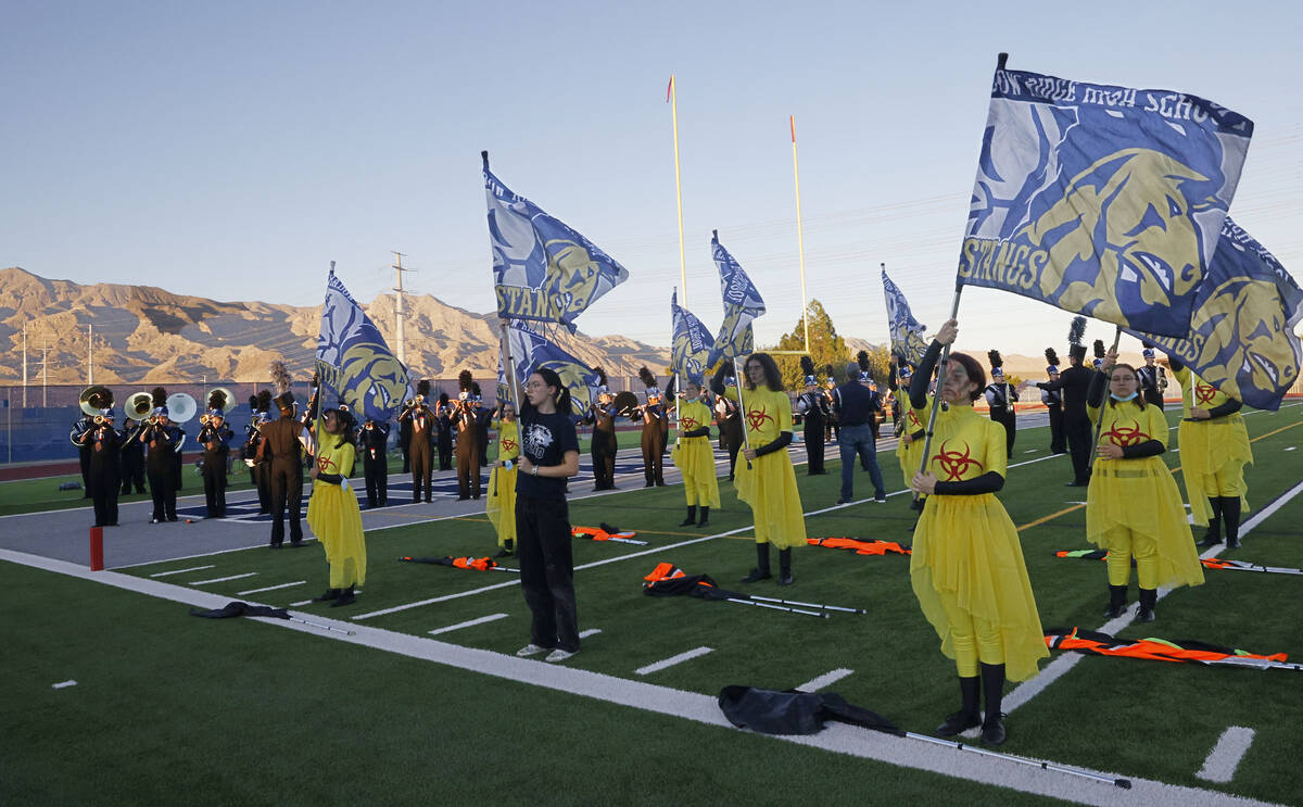 Shadow Ridge High School marching band color guard members perform before a football game again ...