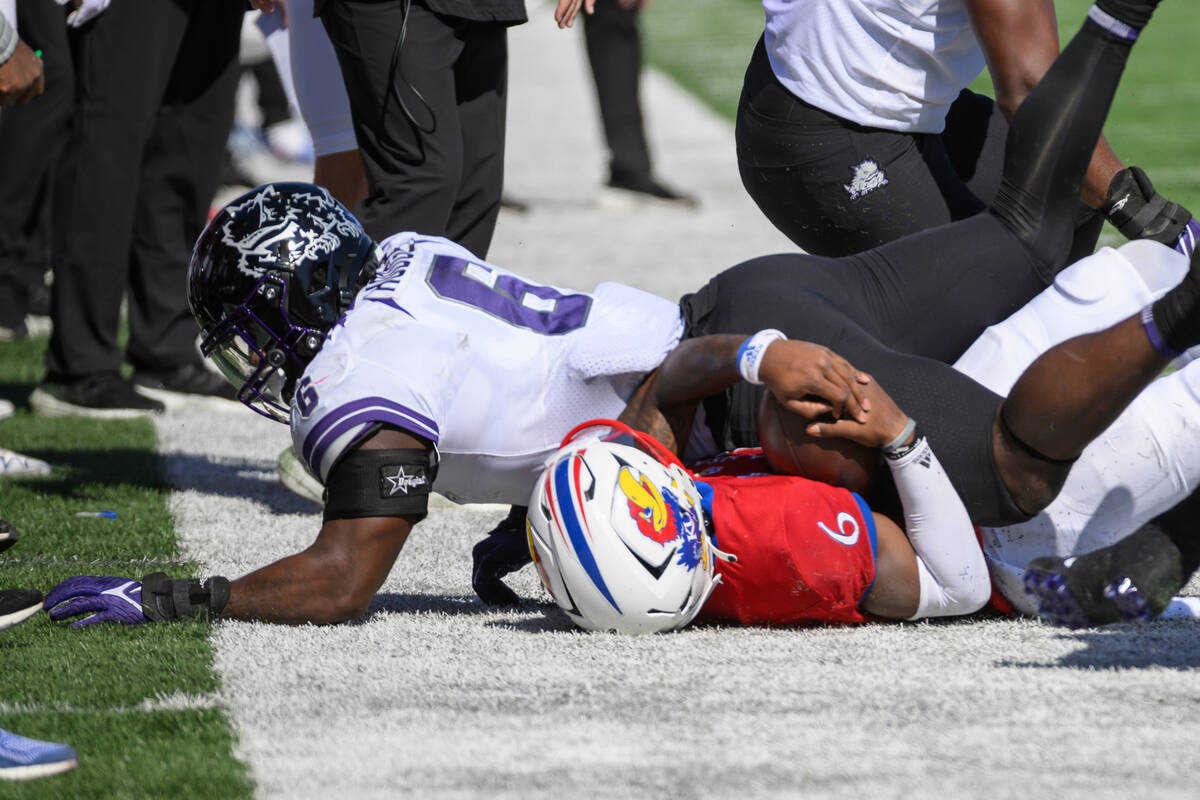 Kansas quarterback Jalon Daniels (6) is knocked out of bounds by TCU linebacker Jamoi Hodge (6) ...