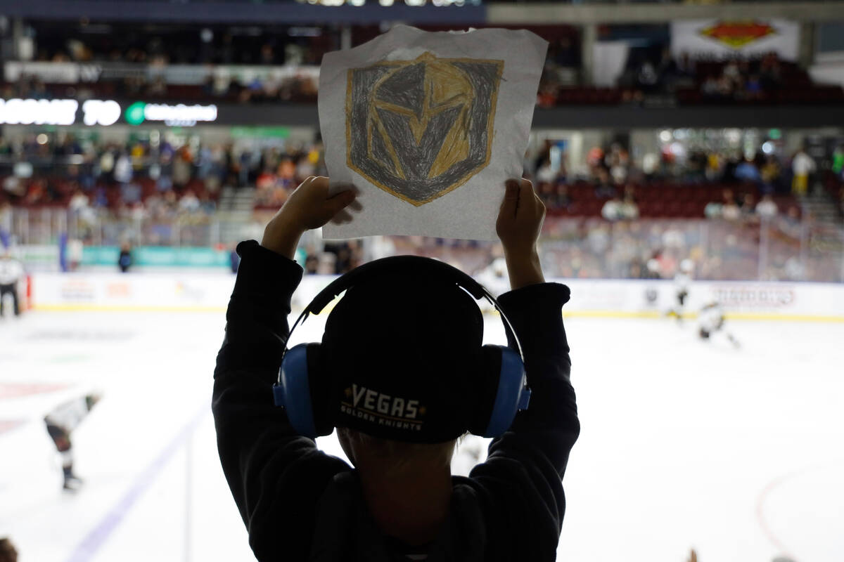A young Vegas Golden Knights fan holds up a sign before a preseason NHL hockey game against the ...