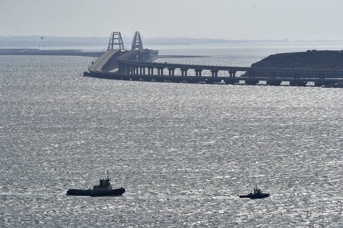 A helicopter flies to drop water to stop fire on Crimean Bridge connecting Russian mainland and ...