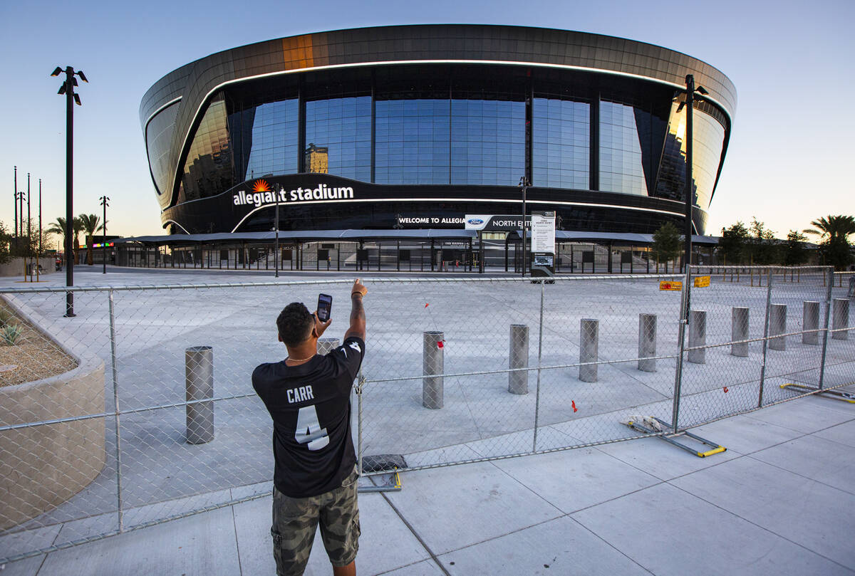 Las Vegas Raiders fan Paul Davis, of Santa Maria, Calif., points to Allegiant Stadium while rec ...