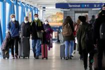 FILE - Travelers walk through Terminal 1 at O'Hare International Airport in Chicago, on Dec. 30 ...