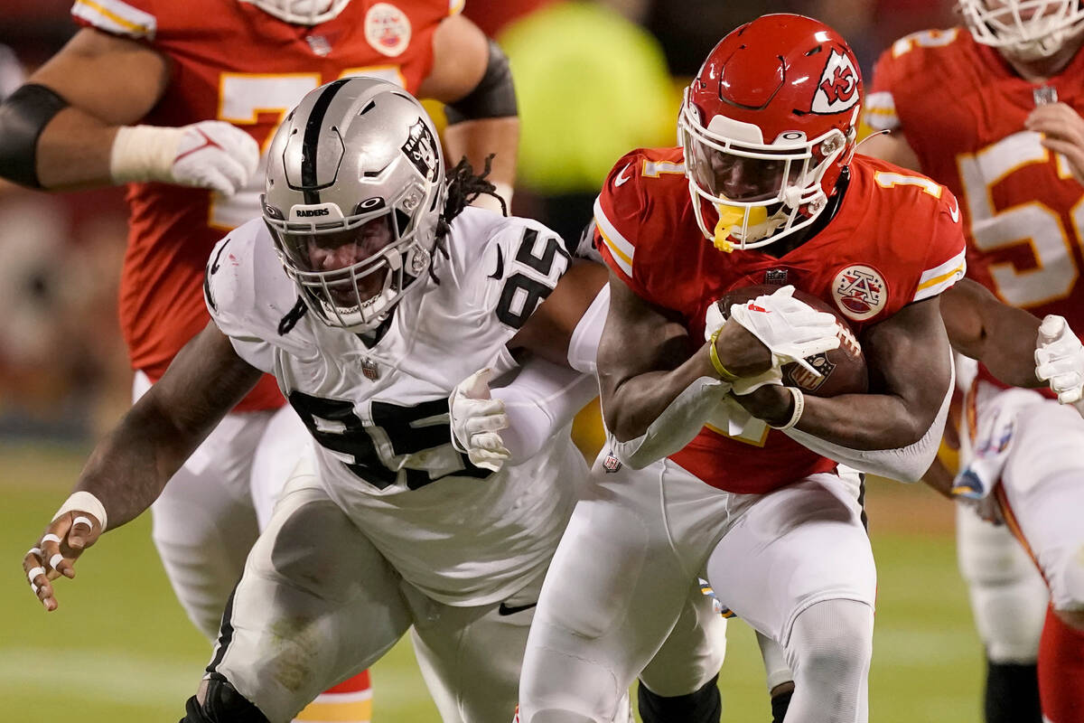 Kansas City Chiefs running back Jerick McKinnon, right, runs for a first down as Las Vegas Raid ...