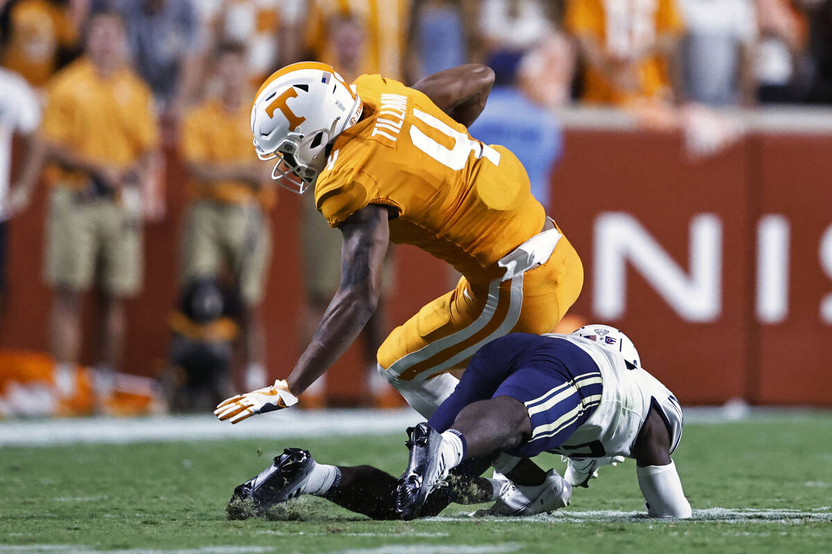Tennessee wide receiver Cedric Tillman (4) is hit by Akron cornerback Tyson Durant (28) during ...