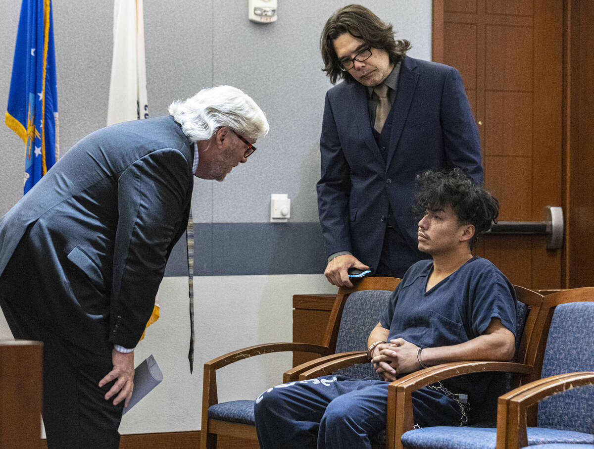 Yoni Barrios consults with Scott Coffee, left, and Jeff Maningo, public defenders, during a sta ...