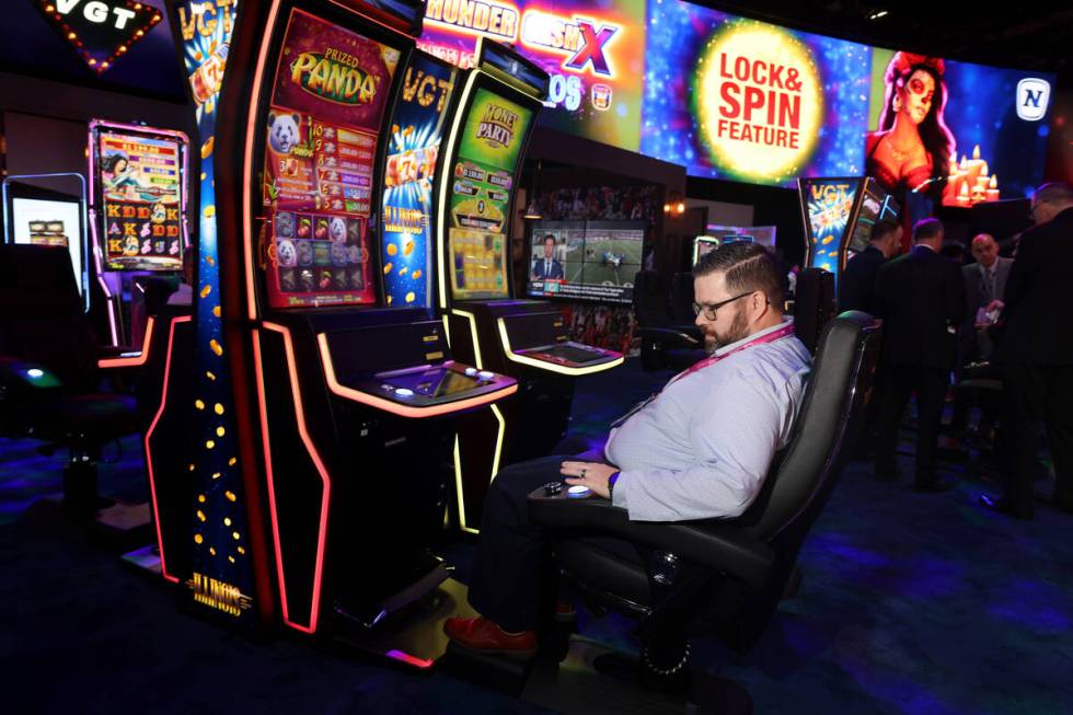 Jason Voltz of Las Vegas uses buttons on the arm rest while playing on a VIP slot cabinet in th ...