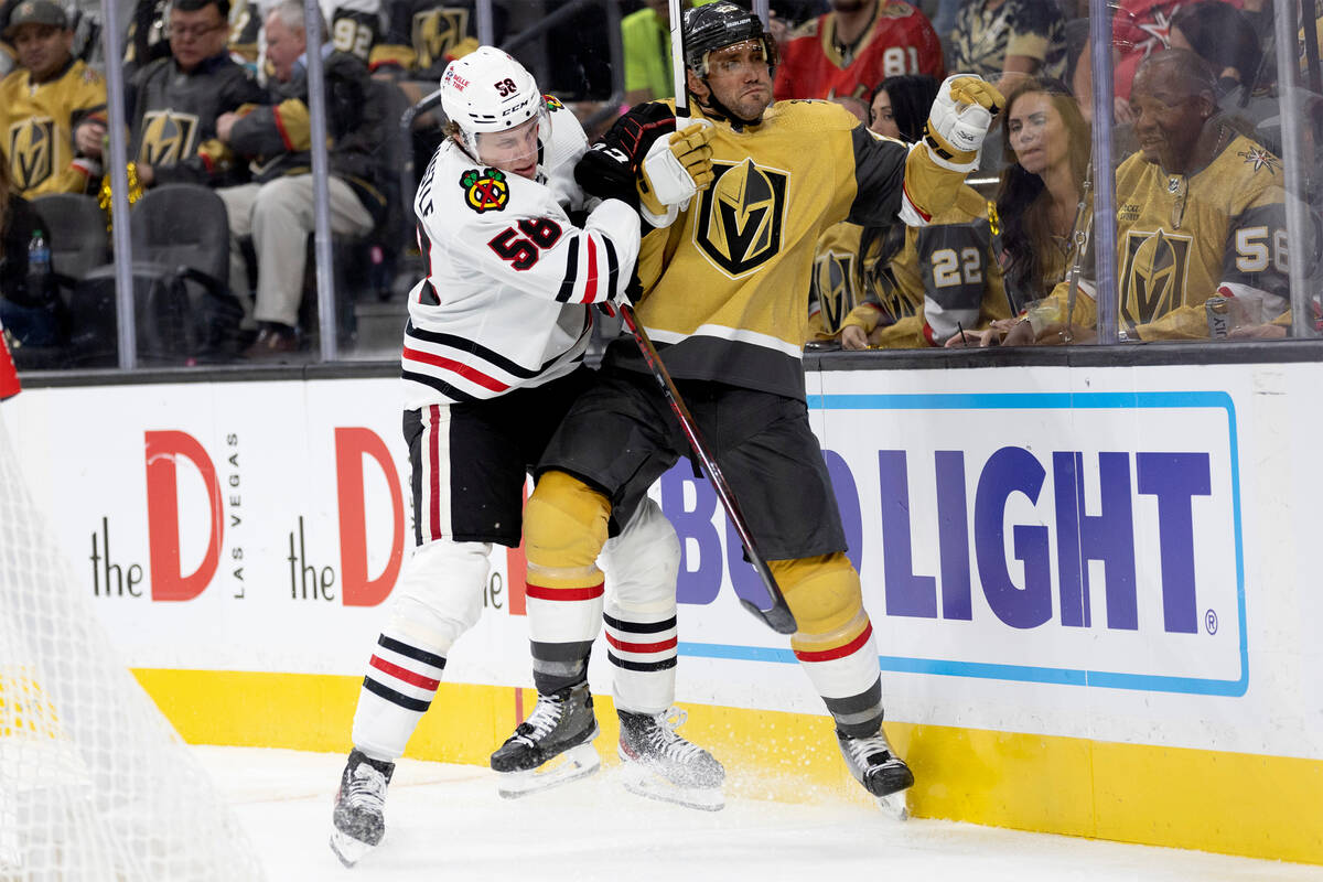 Blackhawks right wing MacKenzie Entwistle (58) slams Golden Knights defenseman Alec Martinez (2 ...