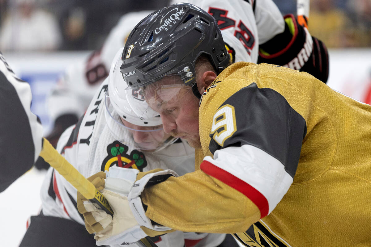 Golden Knights center Jack Eichel (9) faces off with Blackhawks center Sam Lafferty (24) during ...