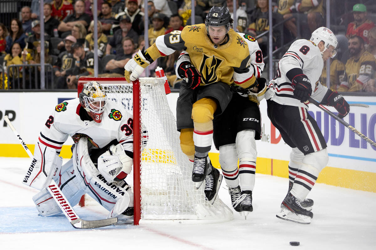 Golden Knights center Paul Cotter (43) collides with Blackhawks defenseman Caleb Jones (82) whi ...