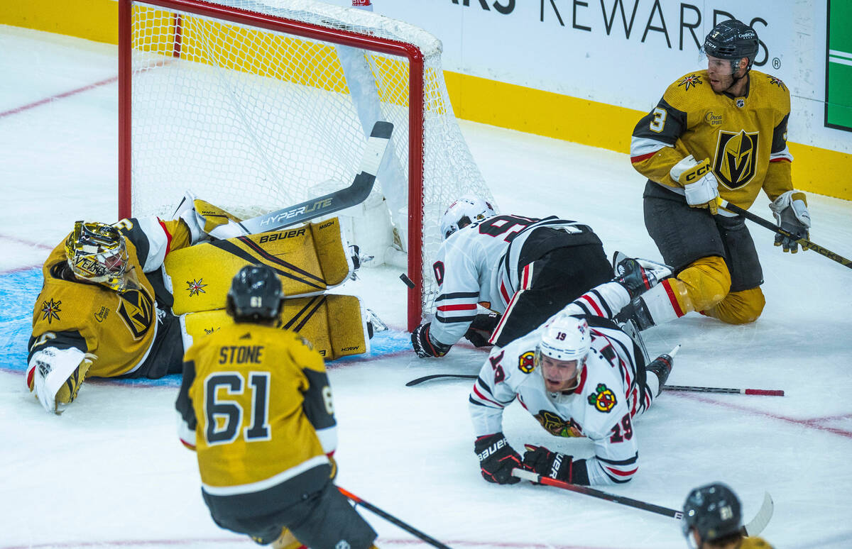 Golden Knights goaltender Logan Thompson (36) deflects a shot off with Chicago Blackhawks cente ...