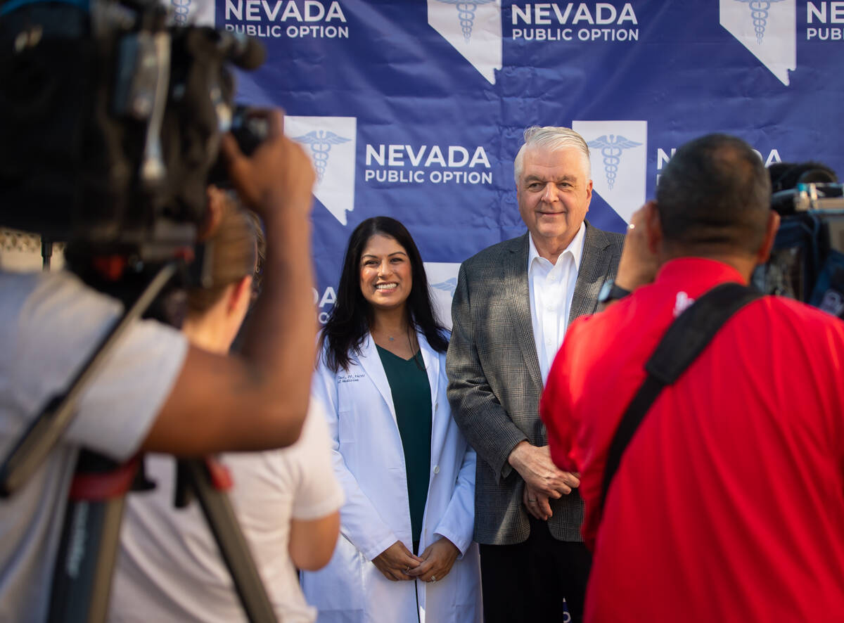 Dr. Harpreet Tsui poses for photos with Gov. Steve Sisolak after a press conference on Thursday ...