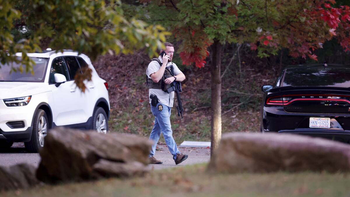Law enforcement officer walks at the entrance to Neuse River Greenway Trail parking at Abington ...