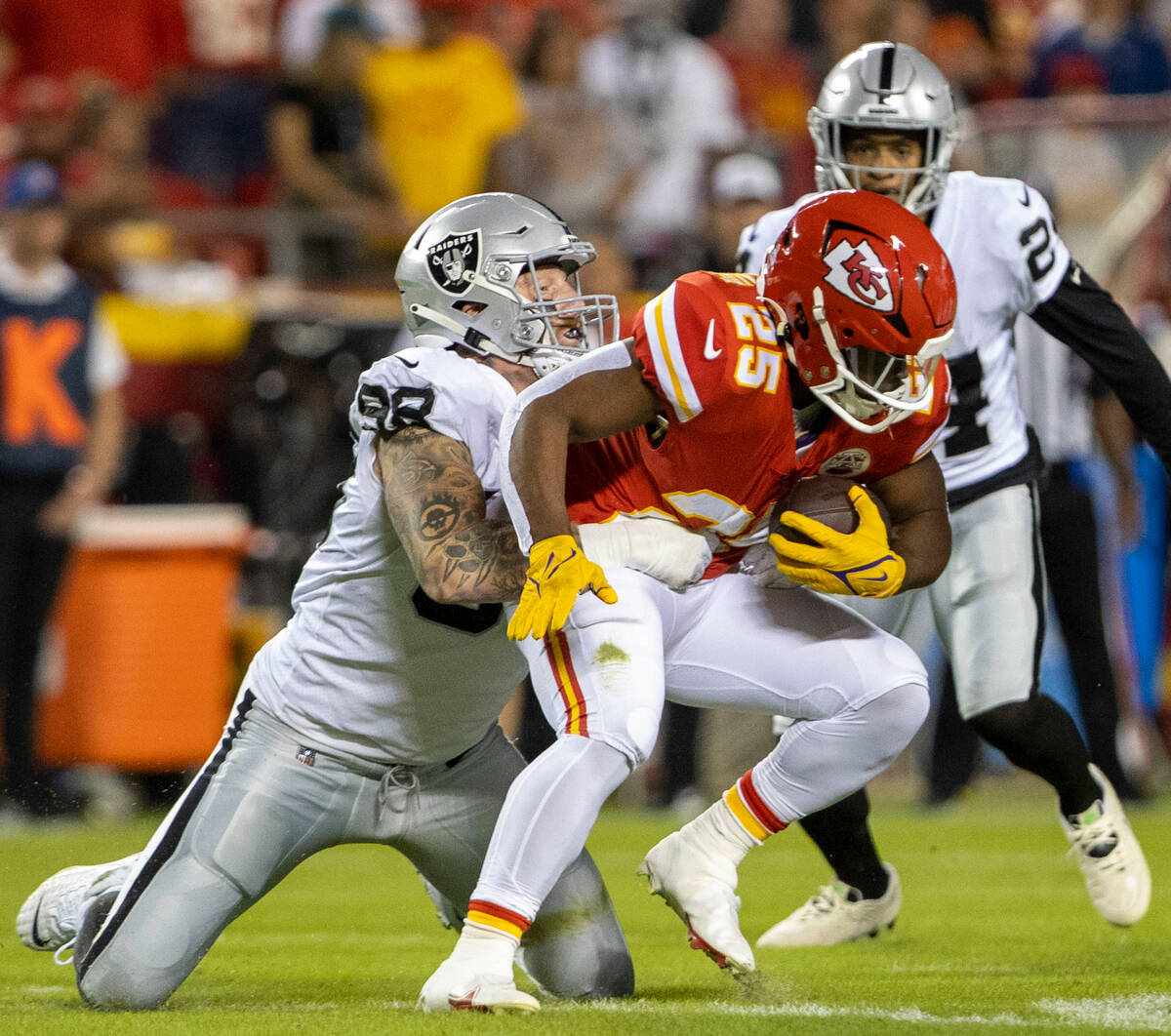 Raiders defensive end Maxx Crosby (98) tackles Kansas City Chiefs running back Clyde Edwards-He ...