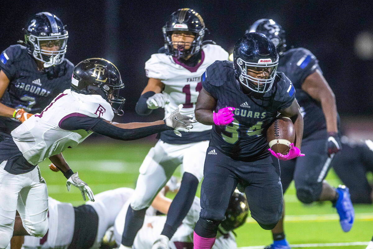 Desert Pines RB Malik Jones (34) evades a tackle attempt by Faith Lutheran's CB Nehemiah Brooks ...