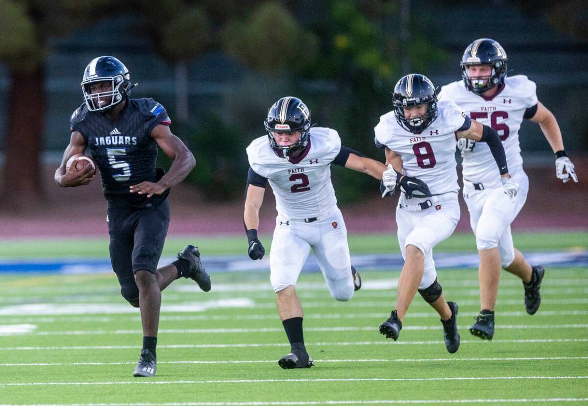 Desert Pines RB Greg Burrell (5) pulls away from Faith Lutheran's CB Ryder Sudbury (2), CB Jack ...