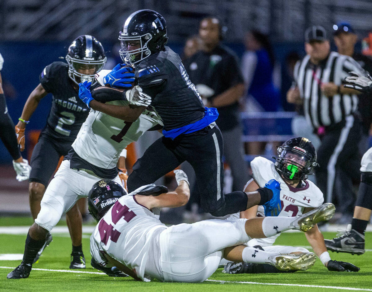 Desert Pines WR Amir Lindsey (17) looks to break a tackle attempt by Faith Lutheran's CB Nehemi ...