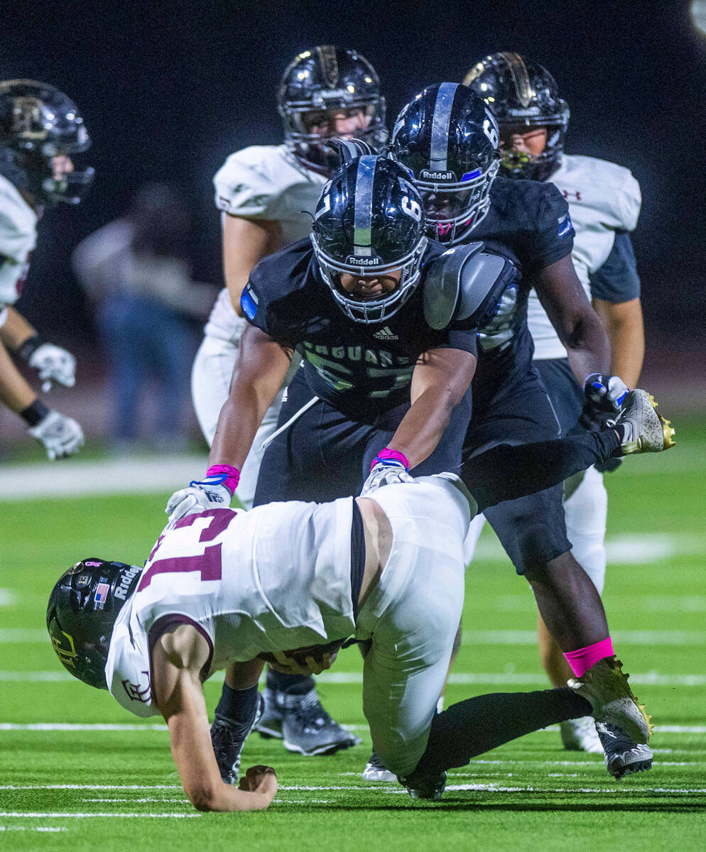 Faith Lutheran's QB Rylan Walter (13) is sacked by Desert Pines DT Tyler Stewart (67) during t ...