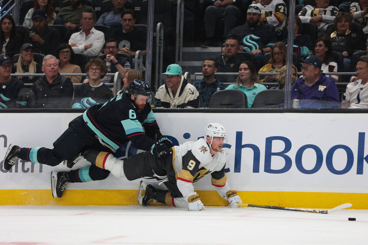 Seattle Kraken defenseman Adam Larsson (6) and Vegas Golden Knights center Jack Eichel fall to ...